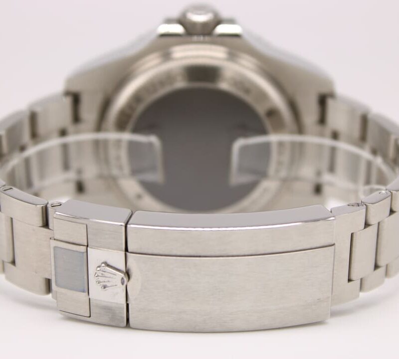 Back view of a stainless steel wristwatch with a brushed metal bracelet and a deployment clasp, showing the Rolex-style crown logo on the clasp.