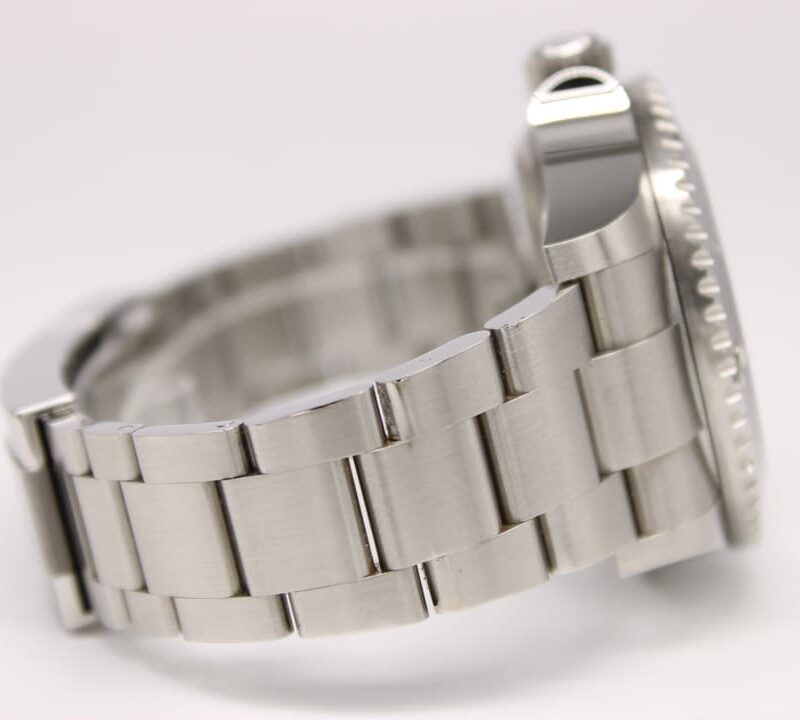 Close-up of a silver metal watch band with a partial view of the watch case in the background, brushed links visible on both sides.